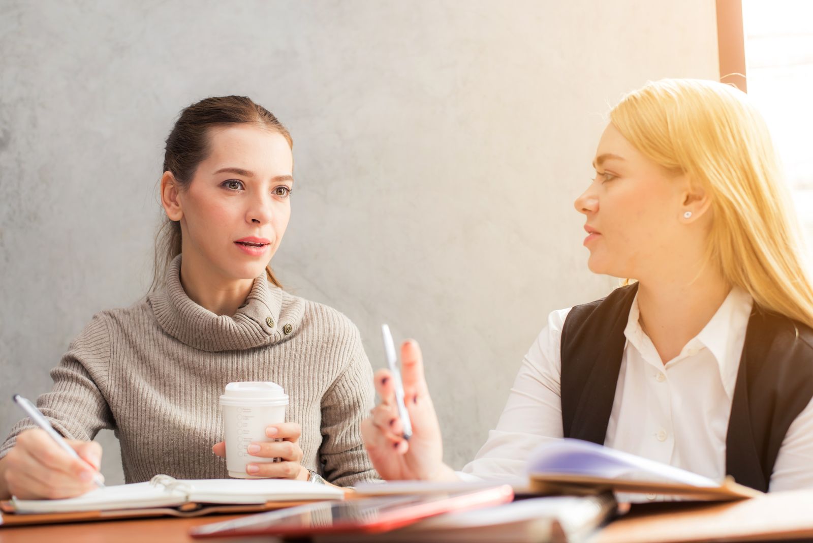Two coworkers in a warm, attentive conversation.